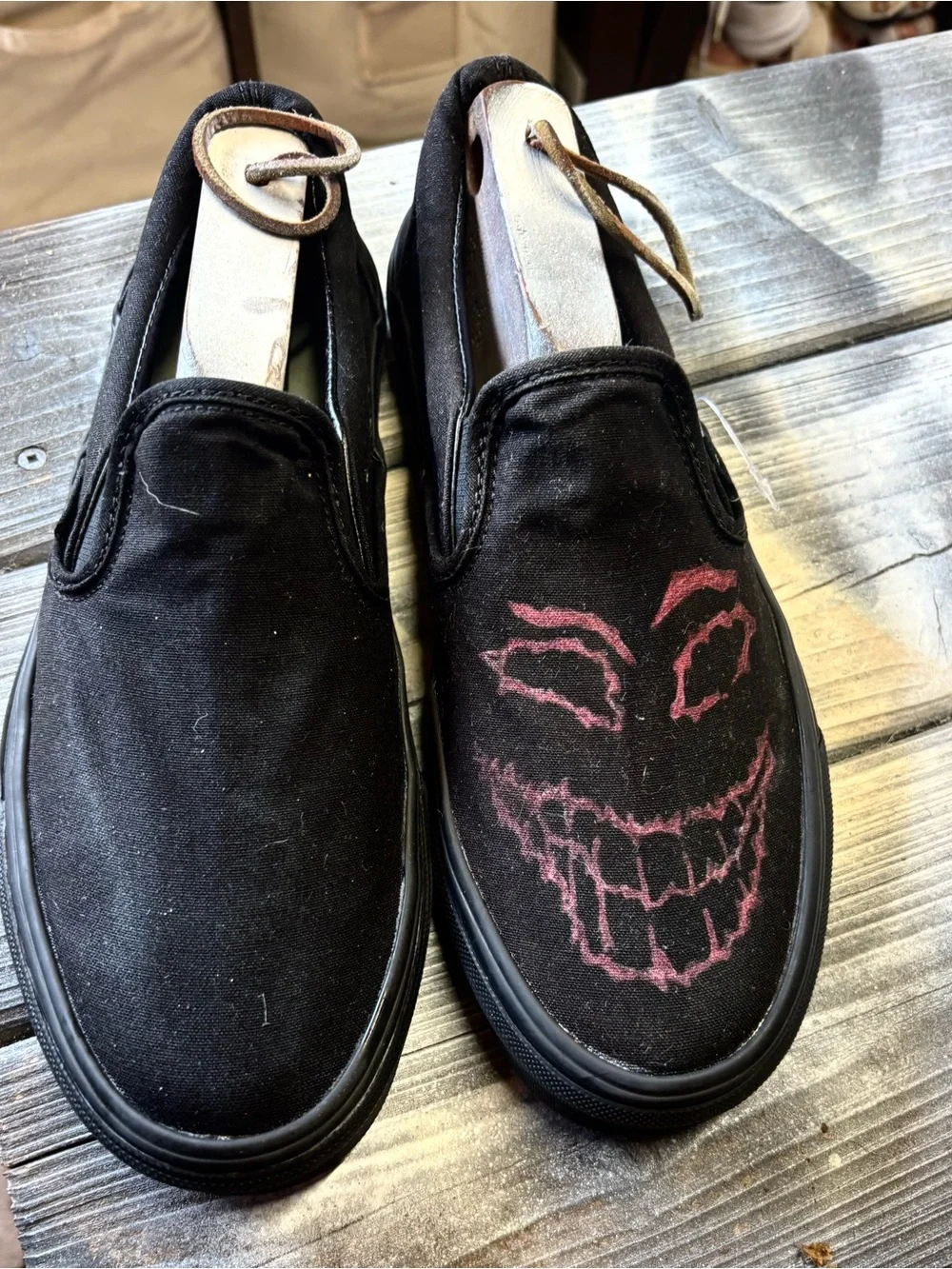 Vans black slip-on canvas sneakers with red hand-painted smiley face